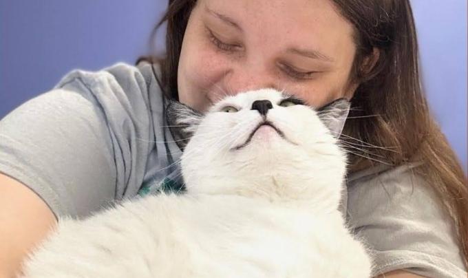 Person snuggling with a black and white cat